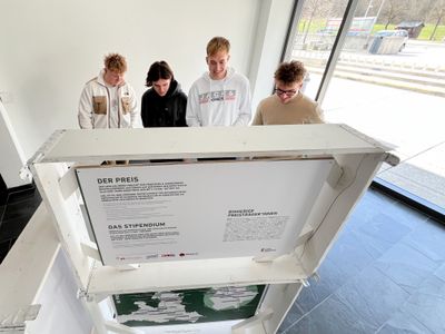 Schüler*innen der HLT Saalfelden betrachten gemeinsam die Ausstellung.